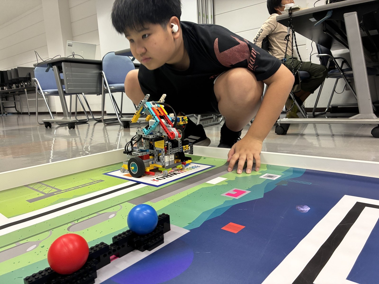 WRO フィールドでロボットを調整する様子